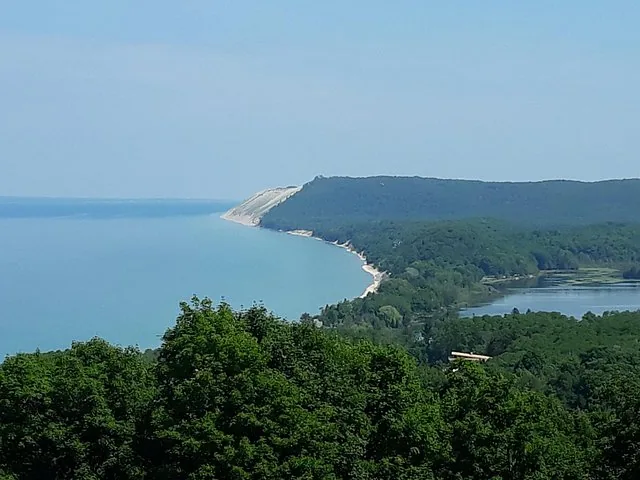 Eine malerische Aussicht auf eine Küste mit bewaldeten Hügeln und einem ruhigen blauen See.