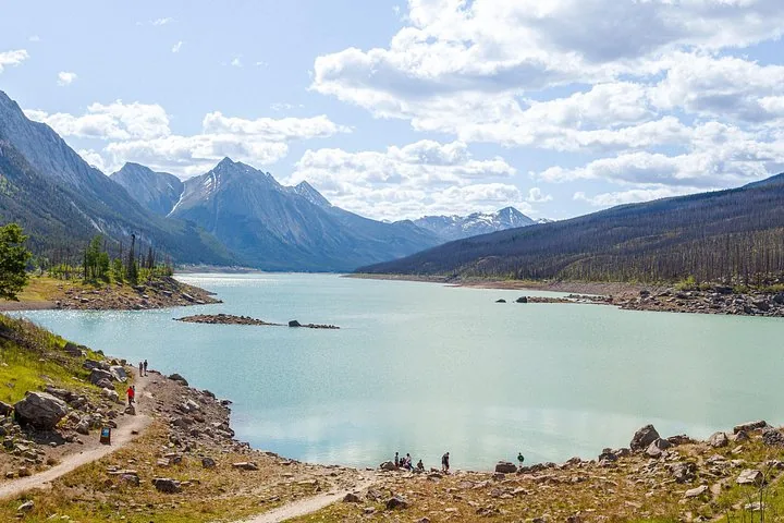 Ein weiter Blick auf einen blauen See, umgeben von Bergen und felsigen Ufern